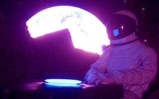 A person moonlighting as an astronaut while working on a laptop with the moon looming in the background.