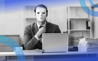 A man sits at a laptop with a mask on