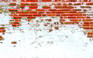 Decolonizing Design, Explained A brick wall whose white paint is slowly chipping away to reveal colorful brick underneath.