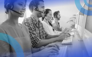 A group of customer service operators work at computer terminals