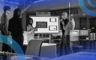 A data science team discusses results on a monitor