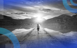A hiker walks along a path into the sun