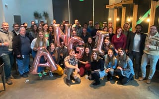 Angi group photo with team members holding ballons that spell ANGI