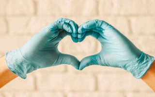 Close up of hands wearing medical gloved making a heart shape