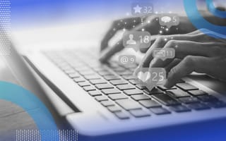 Hands type on a laptop keyboard with social media icons floating above