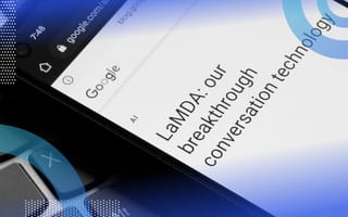 A smartphone screen with "LaMDA: our breakthrough conversation technology" and the Google logo on it