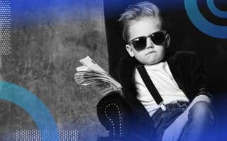 A child in a blazer, suspenders, sunglasses, sits in a wingback chair and waves a fistful of cash. /career-development/5-points-negotiate-executive-compensation