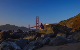 Someone standing on a mountain with the Golden Gate bridge in the background