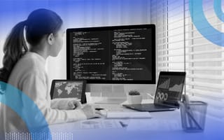 SAST vs. DAST: What’s the Difference? A woman works on multiple computers filled with code and graphics