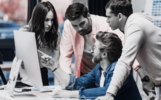 a group surrounding a computer to represent an art director leading visual design