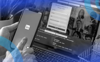 A user looks at LinkedIn on their smartphone while a Zoom meeting happens on a laptop