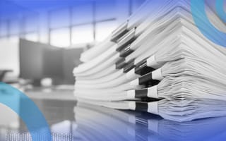 A stack of papers sorted with binder clips on them