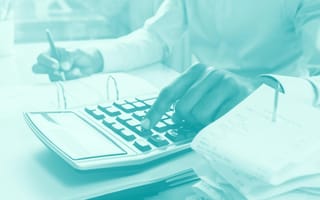 person performing calculations on paper and calculator