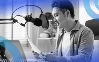 A young man sits in front of a microphone with a script in his hands. /marketing/podcast-that-gets-listeners