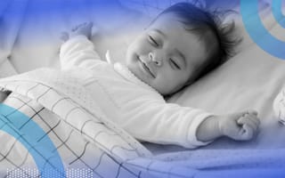 A smiling baby spreads out while sleeping