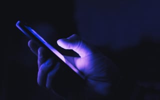 holding cellphone in dark lighting to illustrate shadowban