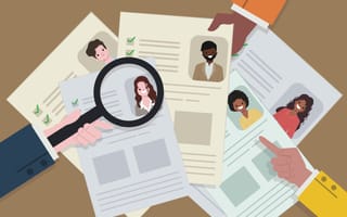 Stack of resumes with a magnifying glass