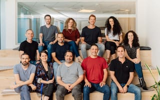 The Monday.com leadership team sits on benches in the office