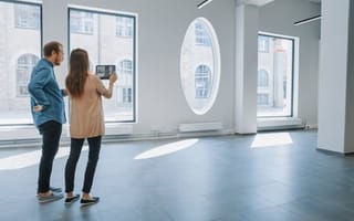 two people stand in an empty residential building