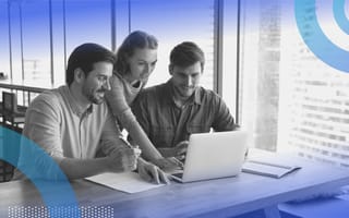 A woman shows two men how to complete a process on a laptop computer