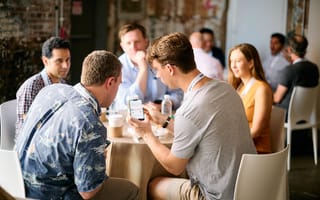 Upside Leadership: How the Company Transforms Everyday Purchases into Greater Change two men looking at a smartphone