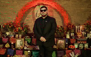 CASHDROP founder and CEO Ruben Flores-Martinez stands in front of a Día de Muertos alter