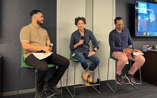 three professionals with microphones on a panel