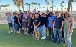 The Blueprint team with palm trees and a blue sky in the background