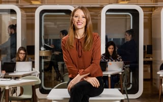 Maven Clinic CEO Kate Ryder sits on a desk in the office