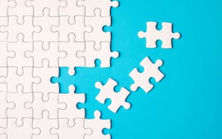 White puzzle pieces being assembled on a bright blue background