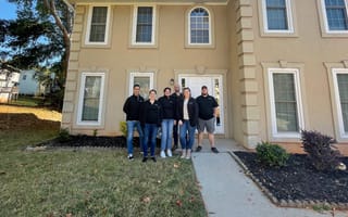 Up&Up employees gather outside a house