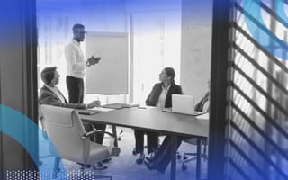 To Foster Innovation, Focus on Mentorship A man gives a presentation at a board in a conference room in front of multiple colleagues