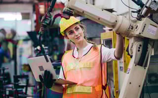 A technician examines a robot in a factory setting