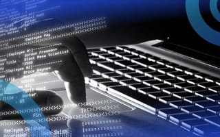 A person editing SQL code on a laptop computer.