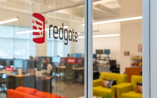 logo of redgate on glass door with view of office
