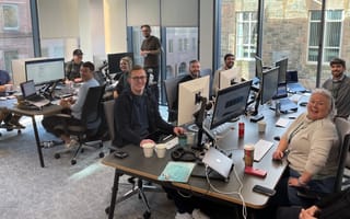 team at their desks looking at the camera