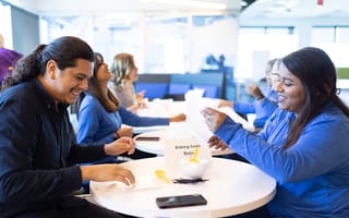 Telesigners smile as they build care kits.