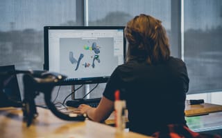 A person faces a computer while designing bicycle parts