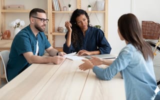 A man and woman sit across the table from another woman