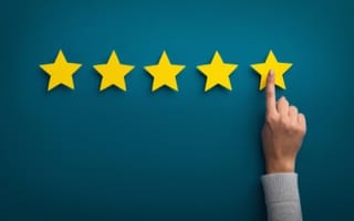 Concept photo of a five star rating with a hand selecting one star
