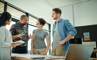 Ascension Strives to Help Transform Healthcare Through Technology. Here’s How They Want to Get There. Team of four colleagues standing at table having discussion