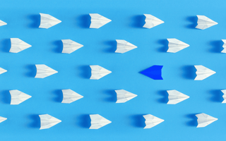 A group of paper planes flying in the same direction except for one.