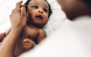 A baby looks up at their parent