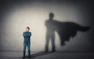 A man stands with a superhero's silhouette displayed behind him.