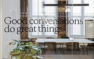 A glass door of a meeting room at OpenWeb. The door has "Good conversations do great things" printed on it.