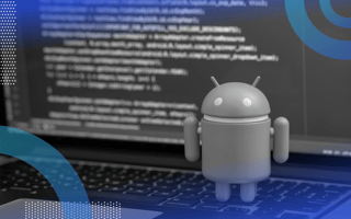 Android development image of the Android droid standing on the keyboard of a computer. Behind the figurine we can see a computer screen covered in code.