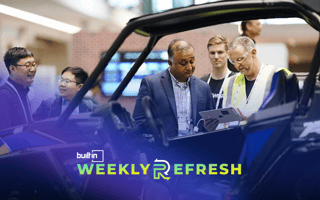 PTC employees look at a vehicle