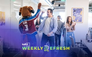 Bernie the St. Bernard high fives a monday.com employee at Monday.com's new Denver office.