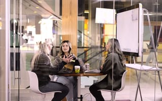 Three people from Cisco Meraki sitting a table in an office