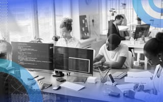 Data wrangling image of an open concept work space with several people sitting in front of desktop computers and focused on working.